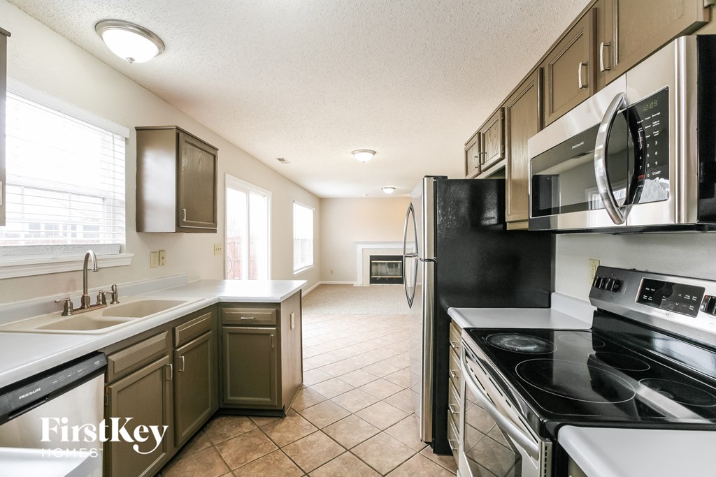 a kitchen with a stove refrigerator and sink
