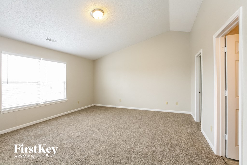a spacious living room with carpet and a large window