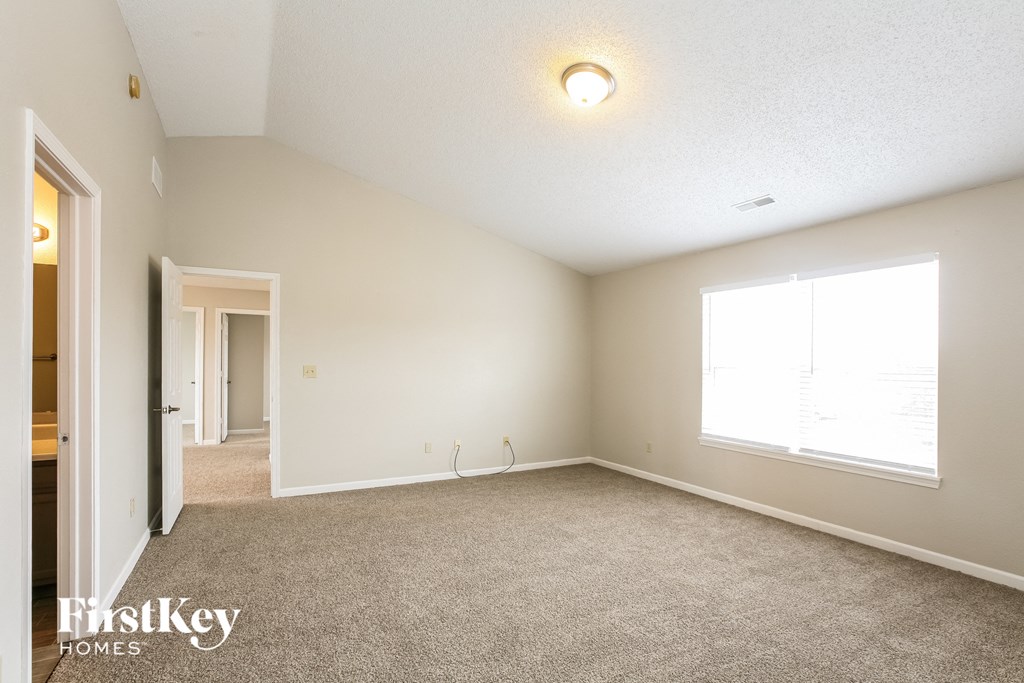 a spacious living room with carpet and a large window