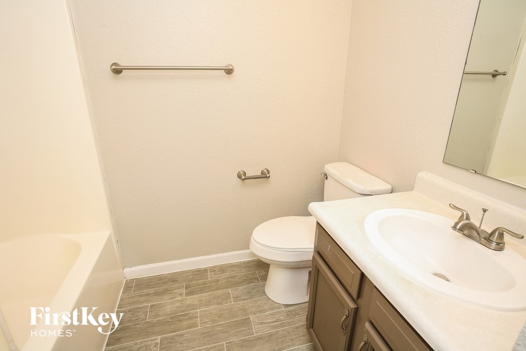 a bathroom with a sink toilet and a mirror