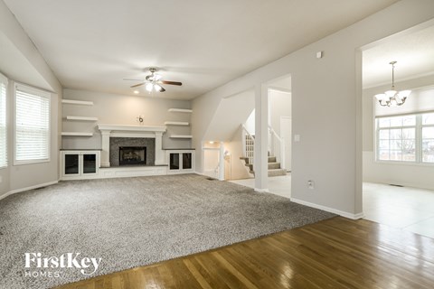a living room with a large rug and a fireplace
