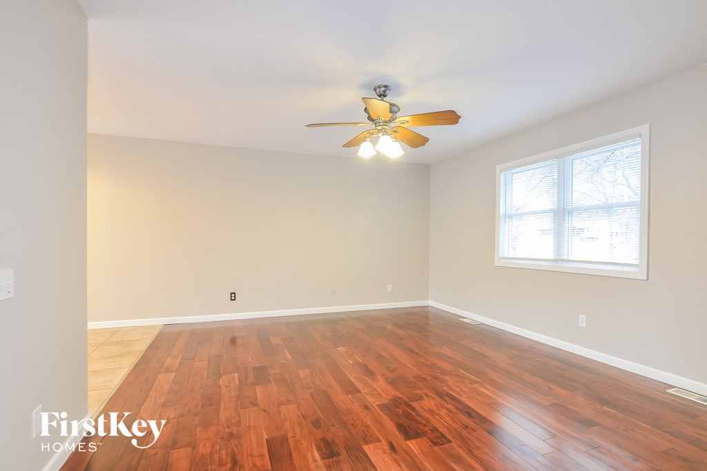 A room with wooden floors and a ceiling fan.