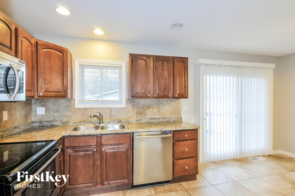 A kitchen with brown cabinets and a stainless steel dishwasher.