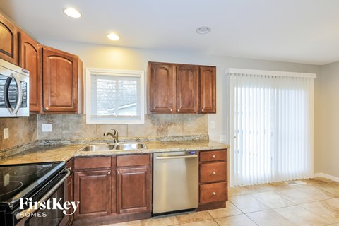 A kitchen with brown cabinets and a stainless steel dishwasher.