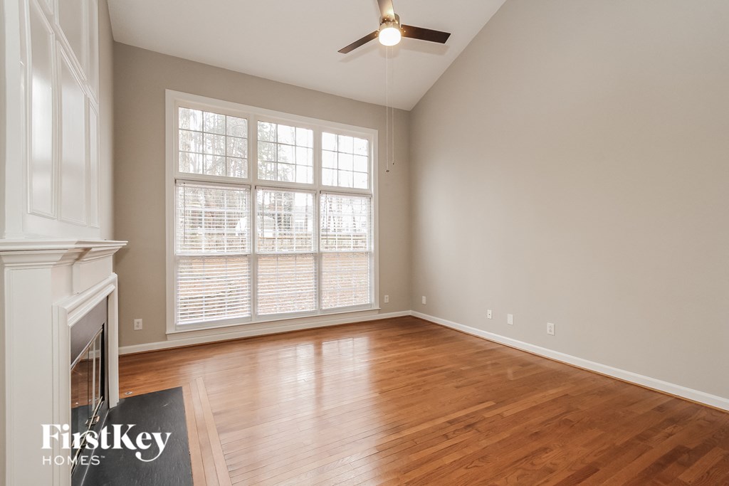 a living room with wood floors and a fireplace and a large window
