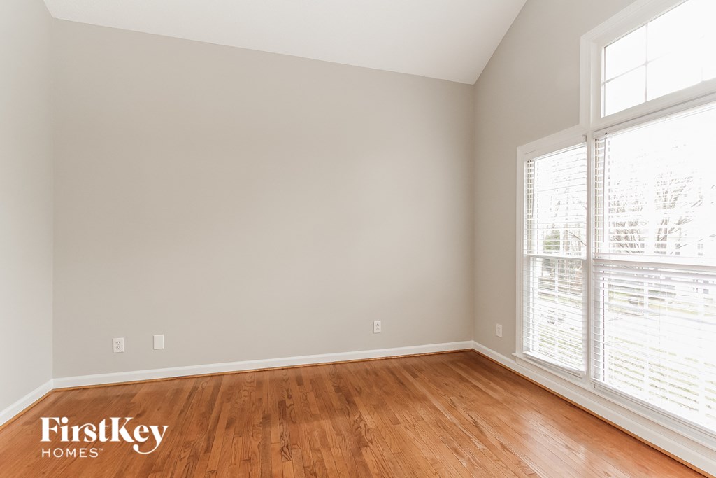 the second bedroom with wood floors and large windows