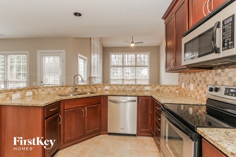 a kitchen with granite counter tops and wooden cabinets
