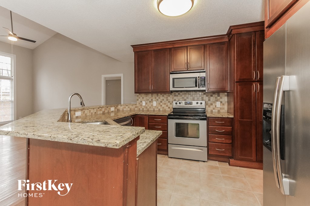 a kitchen with granite countertops and stainless steel appliances