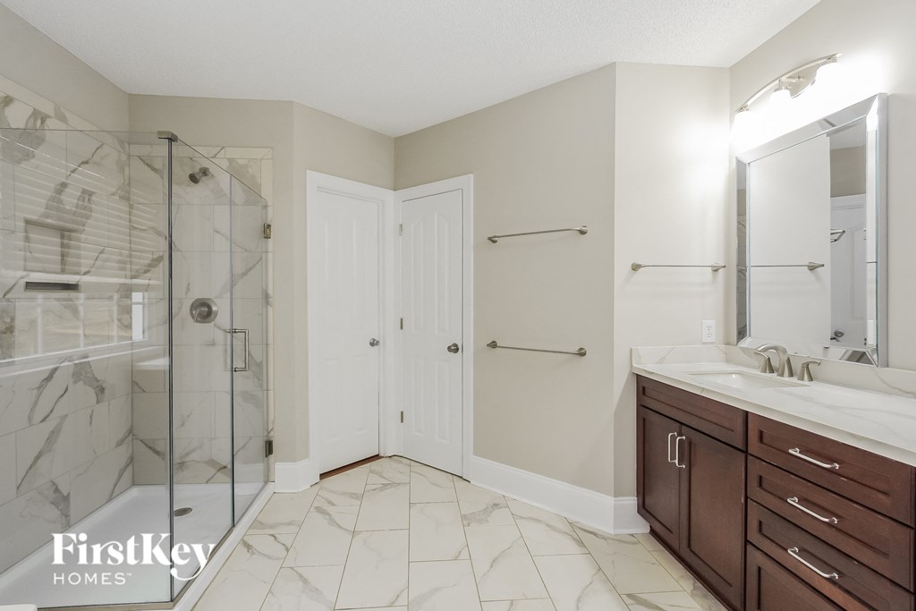 a bathroom with a shower and a sink and a mirror