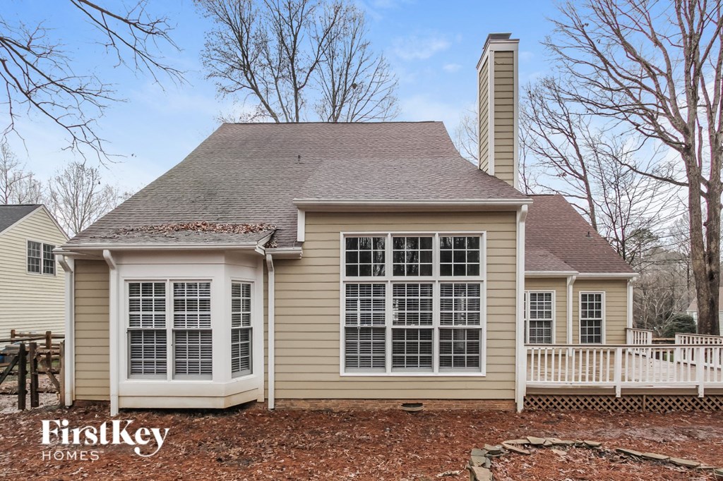a small house with a white fence around it