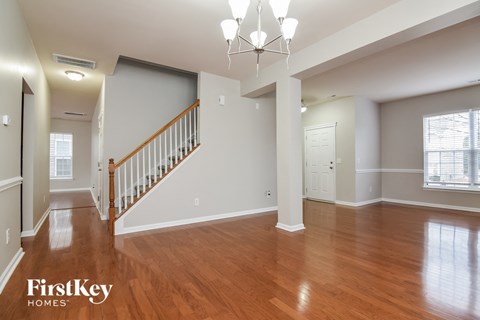 the foyer and living room of a renovated house with hardwood flooring