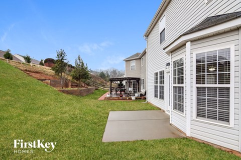 a side view of a house with a patio and a gazebo outside