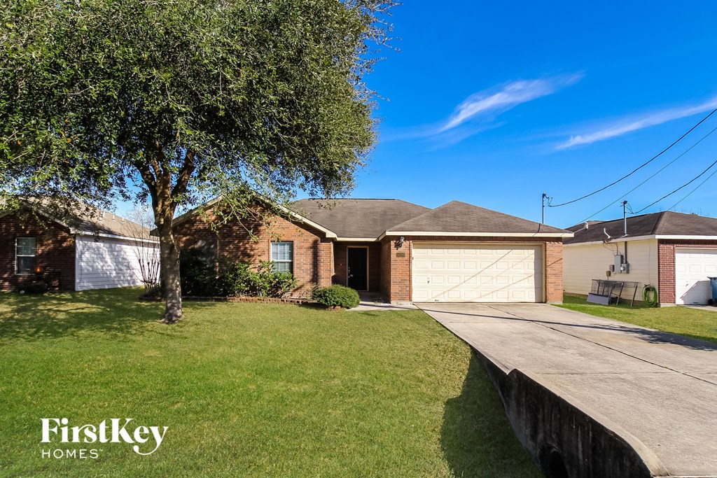 A house with a tree in front and a garage door.