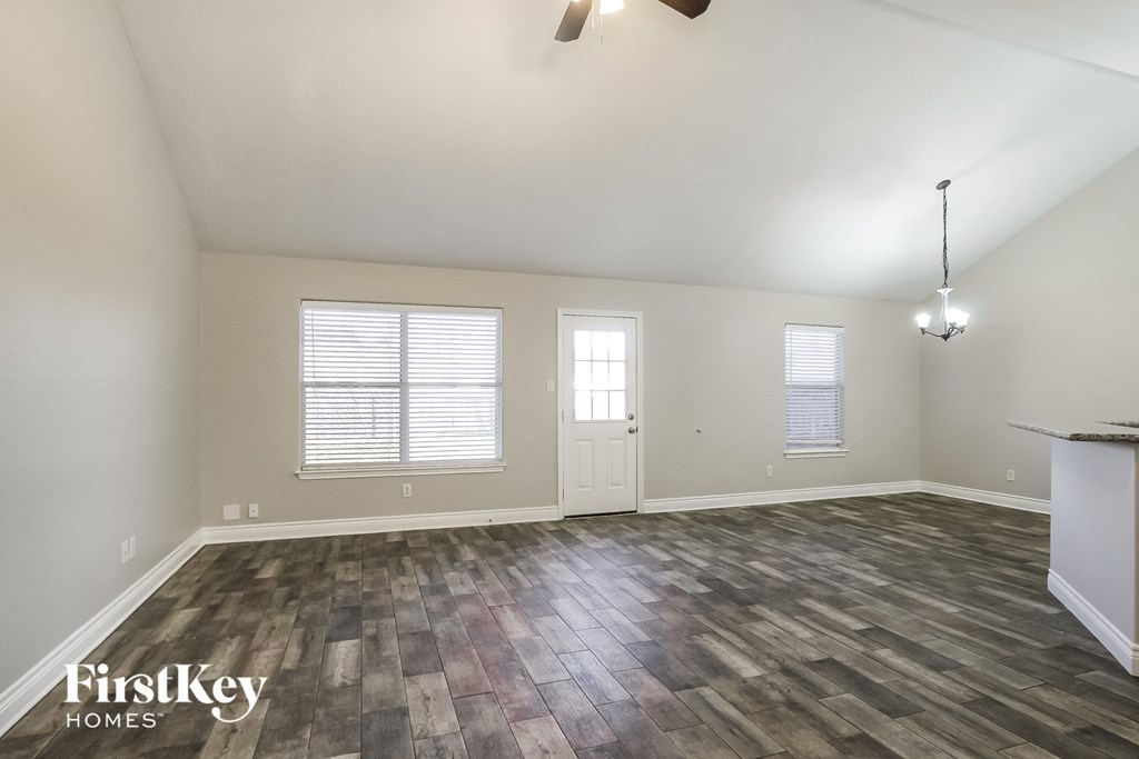 A room with wooden flooring and a ceiling fan.