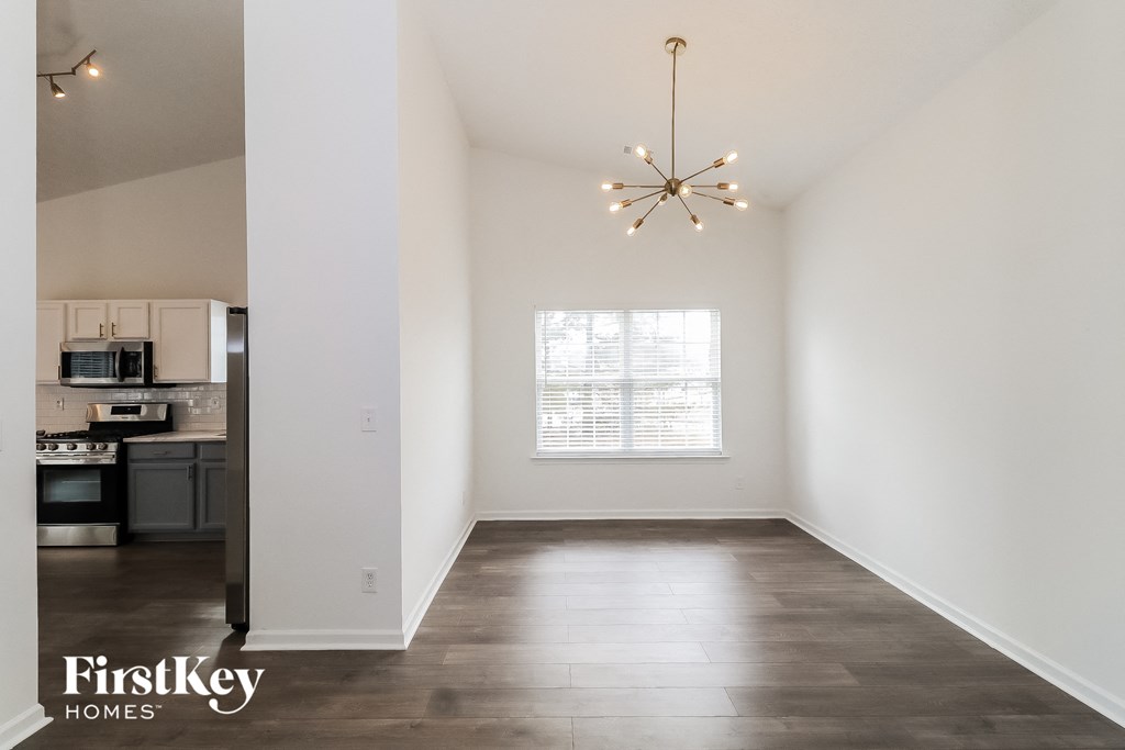 an empty living room with white walls and a window