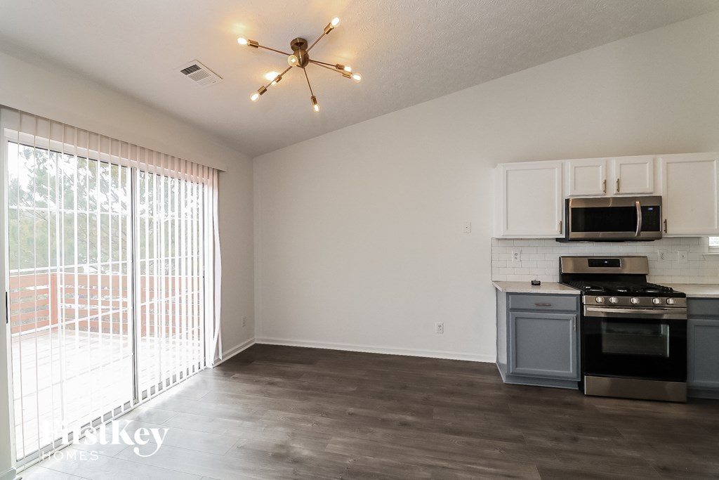 a living room with a kitchen and a large window