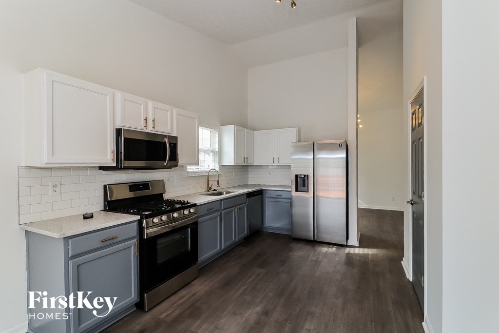 a kitchen with white cabinets and stainless steel appliances