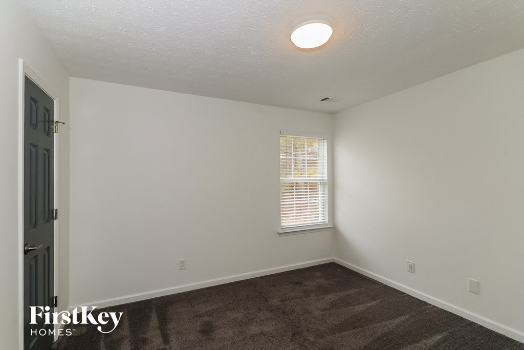 a bedroom with a carpeted floor and a window