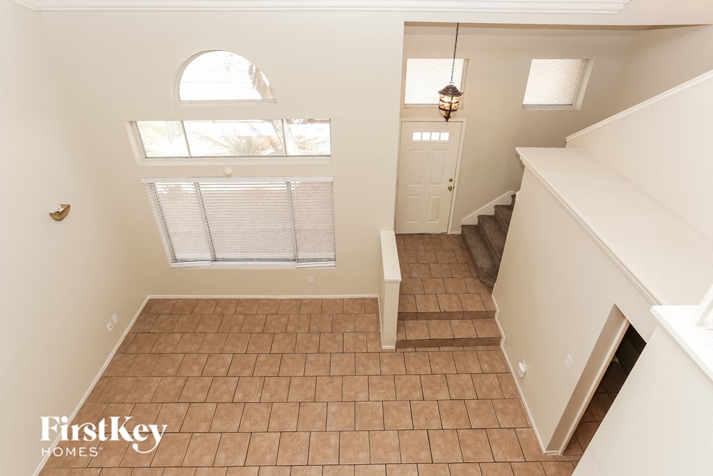 A room with a tiled floor and a staircase.