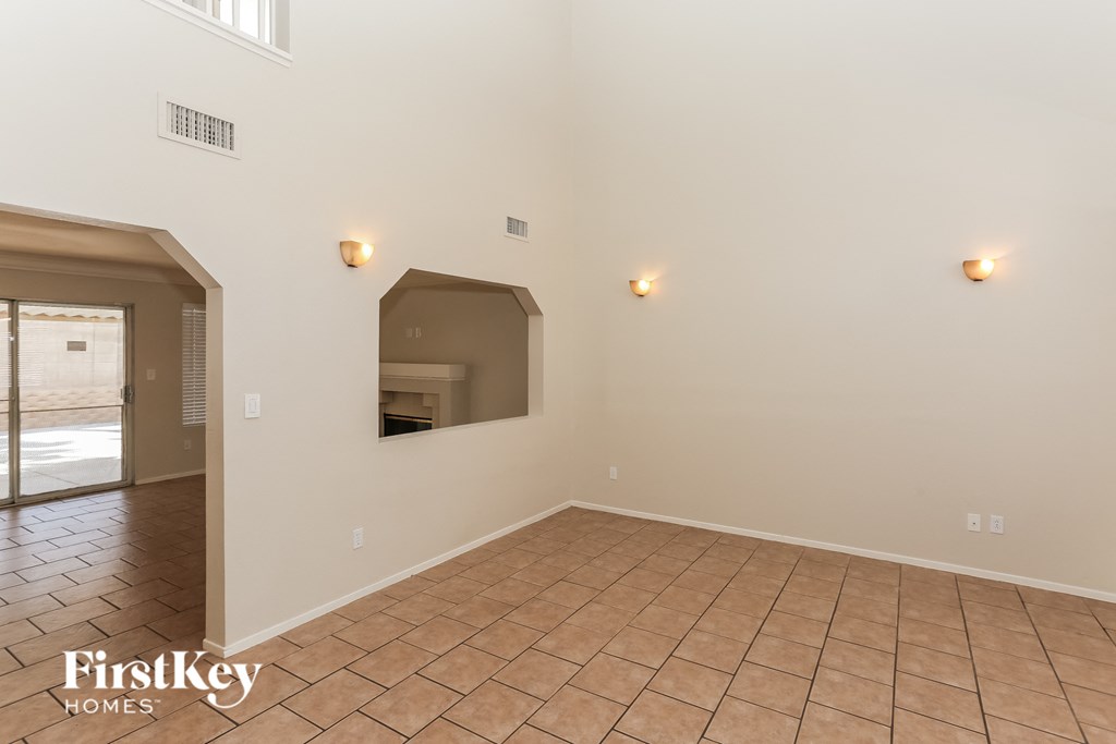A room with a tiled floor and three lights on the wall.