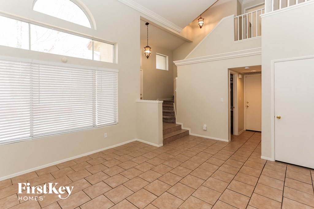 A spacious room with a staircase leading to the upper floor.