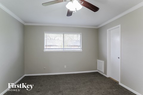 a bedroom with a ceiling fan and a window
