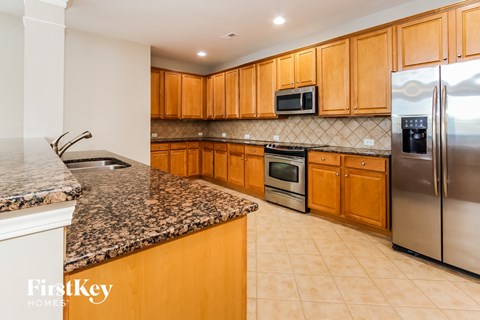 a kitchen with granite counter tops and wooden cabinets and stainless steel appliances
