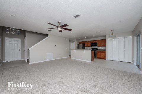 A spacious living room with a staircase leading to the upper level.
