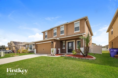 a home with a lawn and a sidewalk in front of it