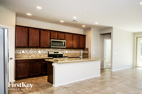 A kitchen with brown cabinets and a white island.