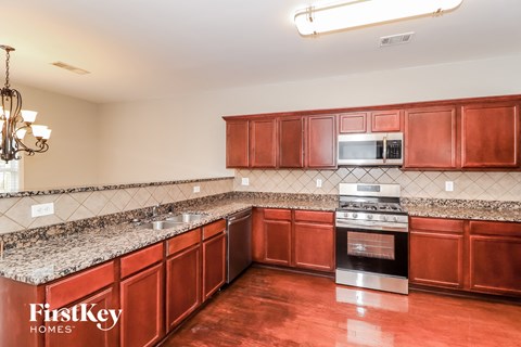 A kitchen with brown cabinets and a stove top oven.