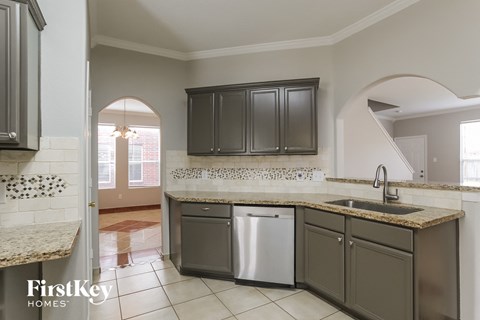 A kitchen with a washer and dryer built into the cabinetry.