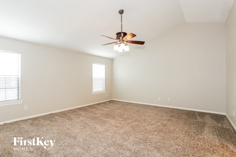 a living room with carpet and a ceiling fan