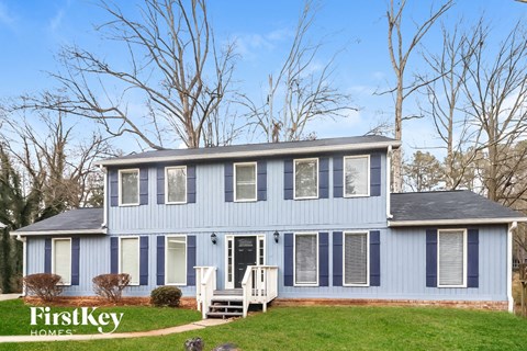a blue house with white rocking chairs in front of it