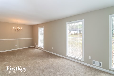 a bedroom with two large windows and a carpeted floor