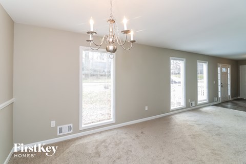 a living room with a chandelier and large windows