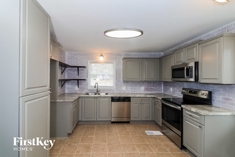 a kitchen with gray cabinets and a sink and a stove