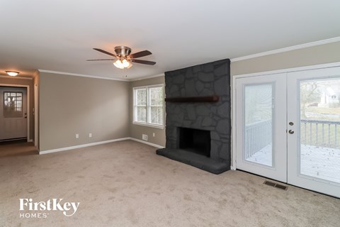 a living room with a fireplace and a ceiling fan
