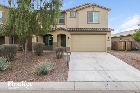 a beige house with a driveway and a garage door