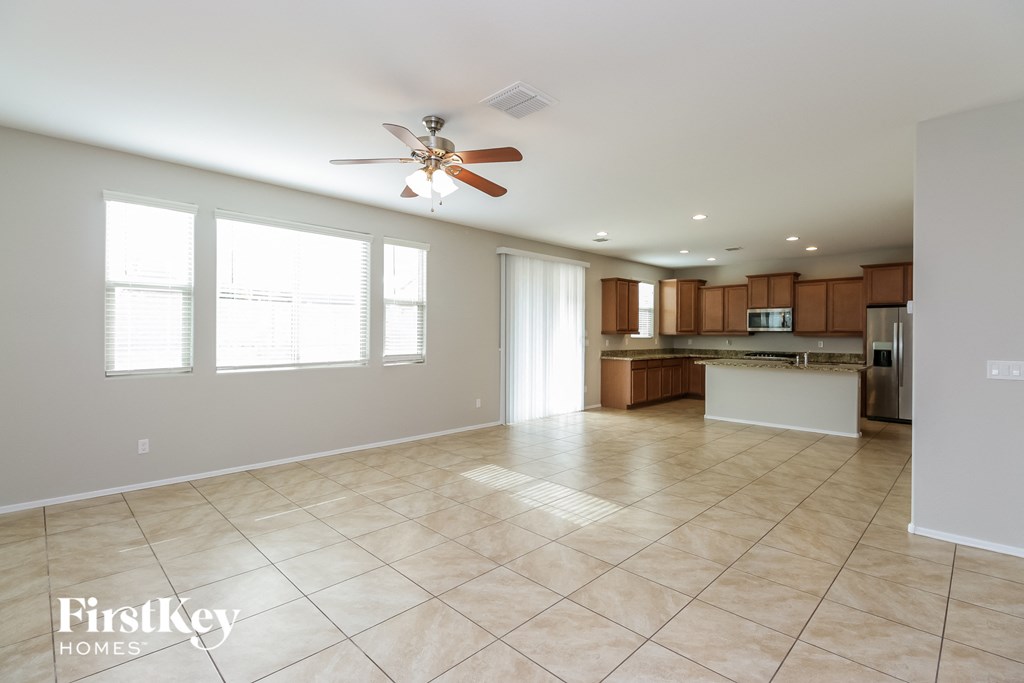 an empty kitchen and living room with a ceiling fan