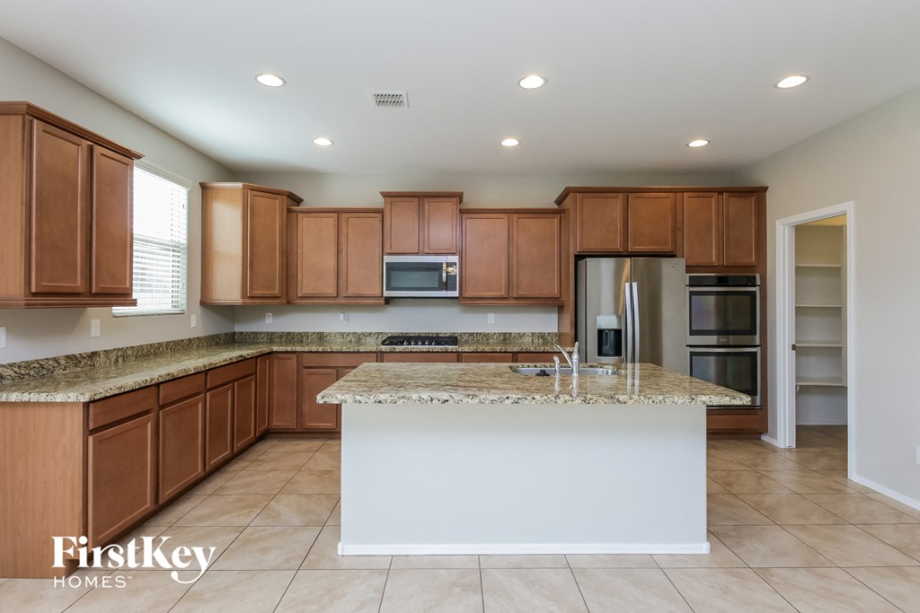 a kitchen with wooden cabinets and a marble counter top