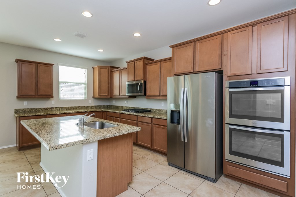 a kitchen with wooden cabinets and stainless steel appliances