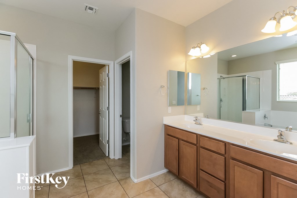 a bathroom with two sinks and a shower and a mirror