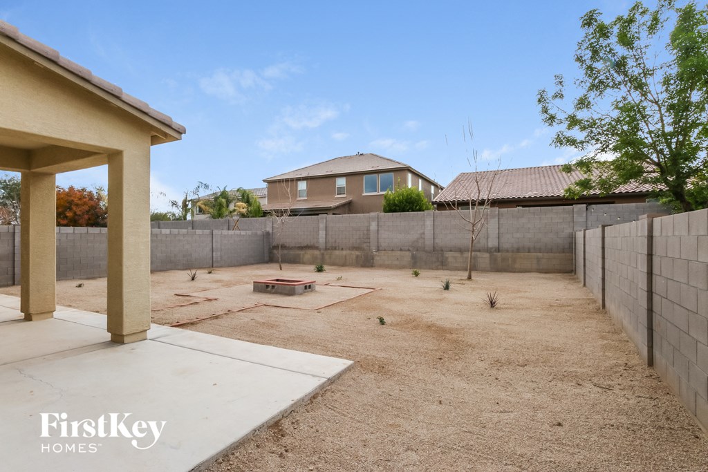 a backyard with a retaining wall and a house