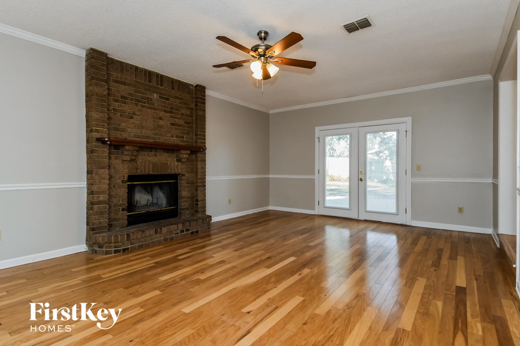 A room with a fireplace and wood flooring.