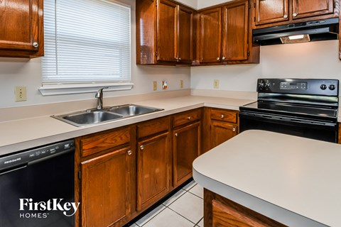 A kitchen with wooden cabinets and a stove top oven.
