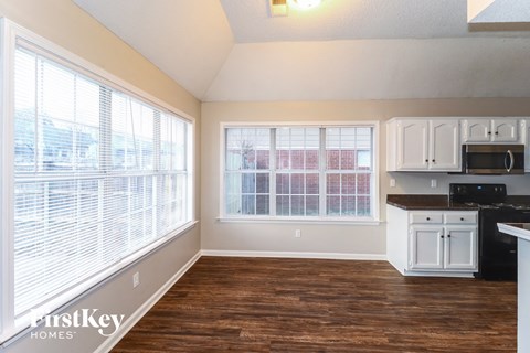 A kitchen with white cabinets and a black countertop.
