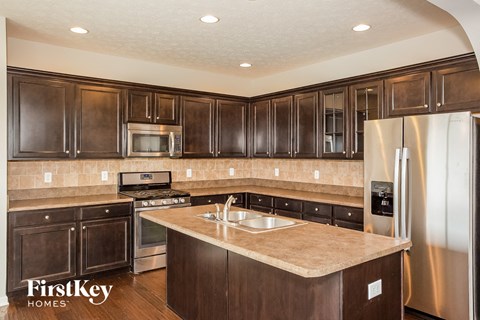 a kitchen with wooden cabinets and stainless steel appliances