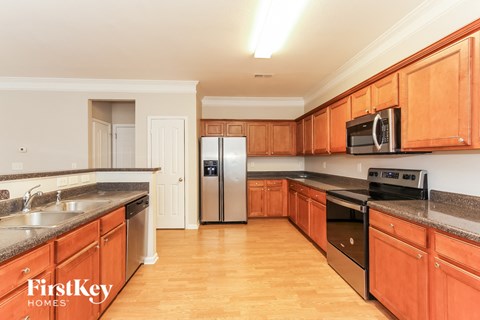 A kitchen with wooden cabinets and a stainless steel refrigerator.