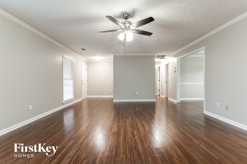 the living room and dining room with hardwood flooring and a ceiling fan